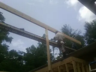 Carpenter setting a ridge beam over a new addition frame — Ice Dam Removal by Roofing Brothers in Marlow